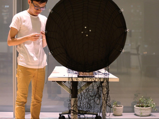 Student spinning yarn on a weaving wheel.